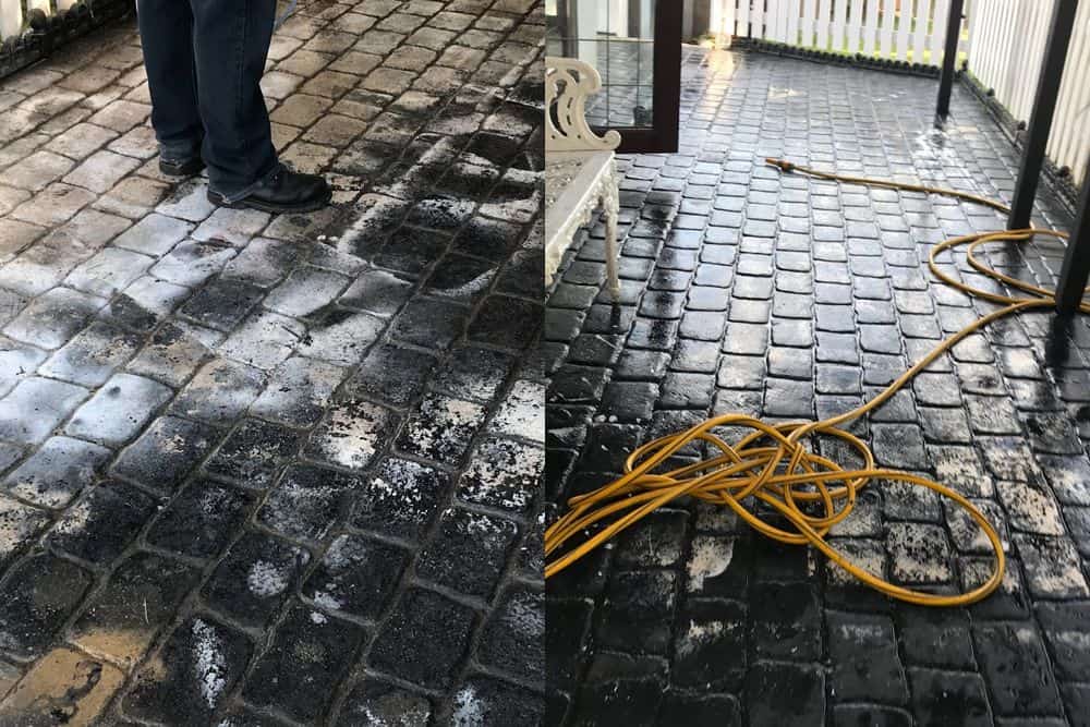 A cobble-effect patio part-way through being pressure washed