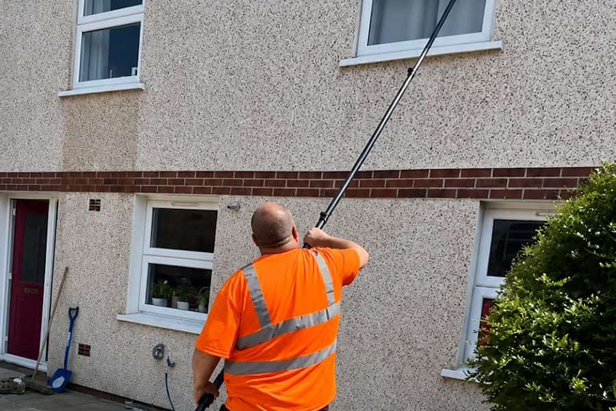 Cleaning an upstairs window from the ground with a water-fed pole