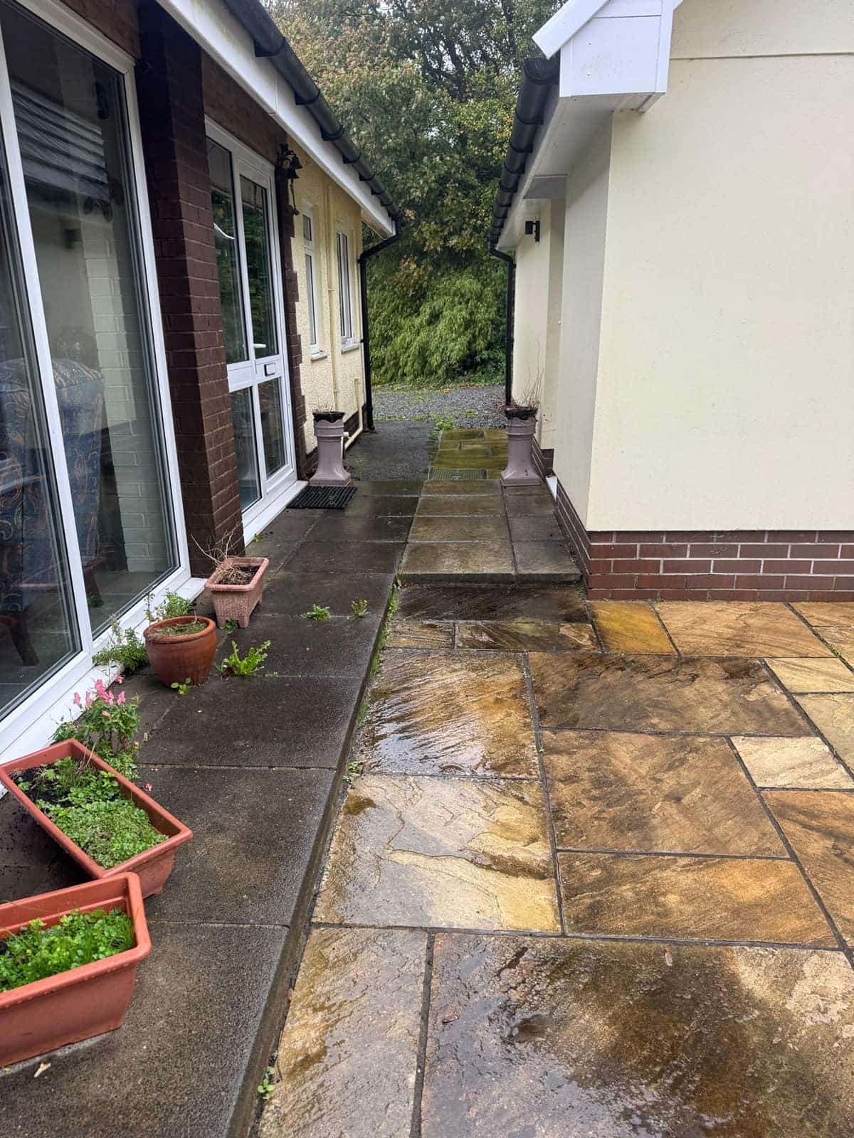 Paved path outside patio doors before cleaning, the slabs dark with dirt