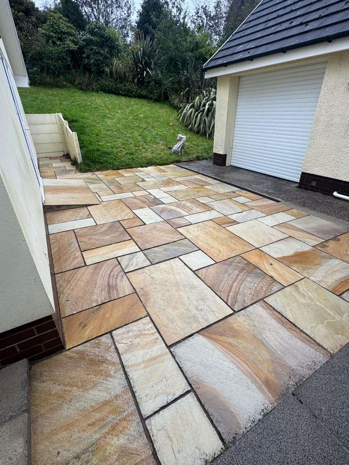 The same patio after pressure washing, with the colours in the sandstone showing again